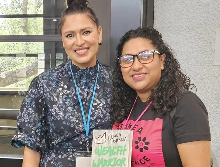 Julia Garrido with a guest holding the book Wealth Warrior